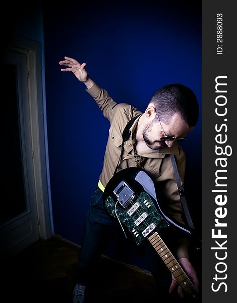 Rocker playing intensely on his guitar. Wide angle view. Rocker playing intensely on his guitar. Wide angle view