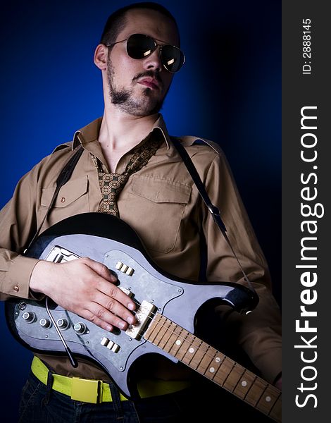 Alternative rocker with guitar hanging out. Dark blue background and vignette. Alternative rocker with guitar hanging out. Dark blue background and vignette.