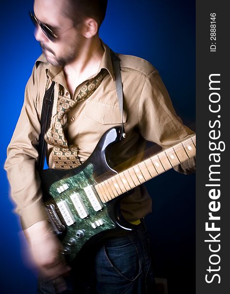 Rocker playing intensely on his guitar. Wide angle view and motion blur. Rocker playing intensely on his guitar. Wide angle view and motion blur.