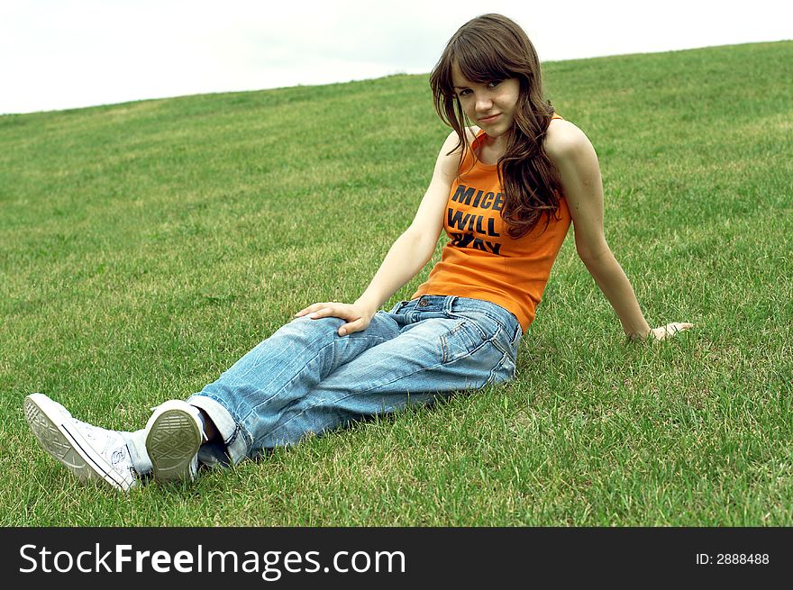 Girl sitting on a green grass. Girl sitting on a green grass