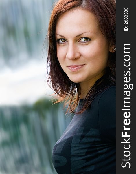 Attractive smiling woman on a background of a waterfall. Attractive smiling woman on a background of a waterfall