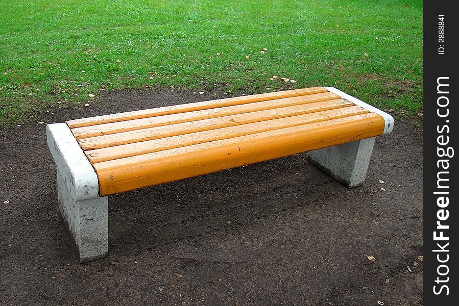 Yellow bench in park after rain