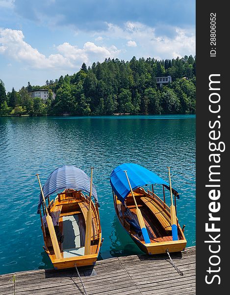 Two row boats floating empty tied to a dock on a lake. Two row boats floating empty tied to a dock on a lake