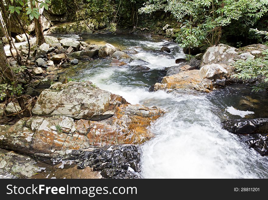 The flowing of waterfall  on big rock that be full of moss