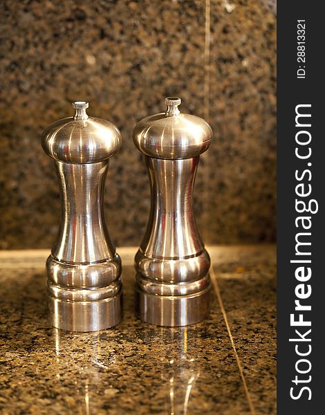 Salt and pepper shakers on a granite counter top.