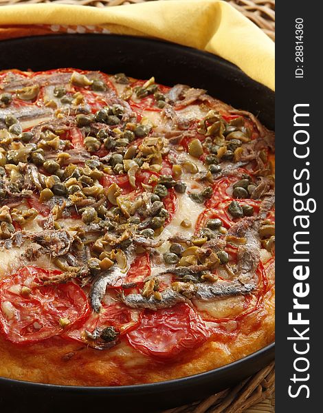 A recipe of pizza with tomato anchovy and capers. A recipe of pizza with tomato anchovy and capers
