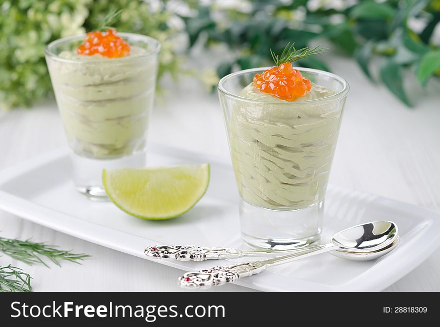 Avocado mousse with caviar portions garnished with a sprig of dill horizontal