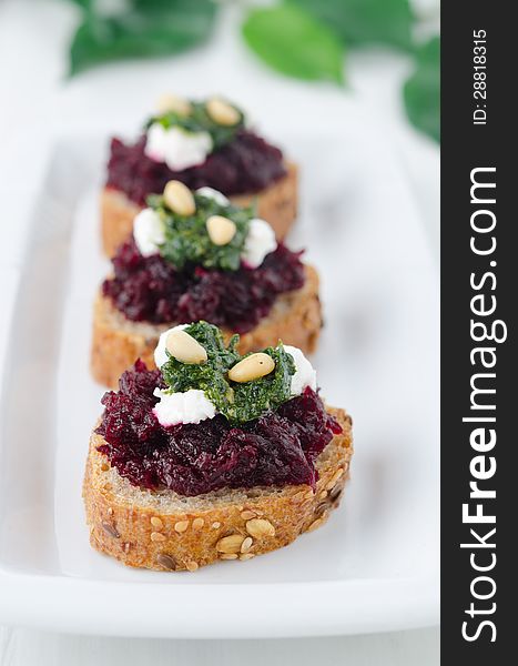 Beet salad with pesto and goat cheese on toasted grain breads