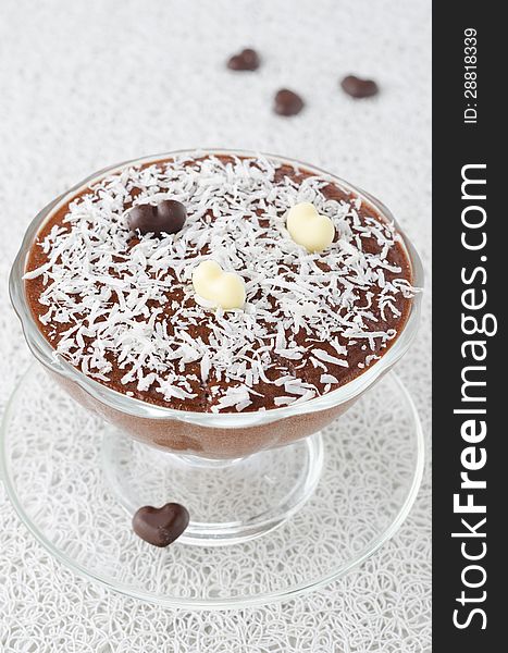 Chocolate mousse with chocolate hearts in a glass sundae dish decorated with coconut. Chocolate mousse with chocolate hearts in a glass sundae dish decorated with coconut