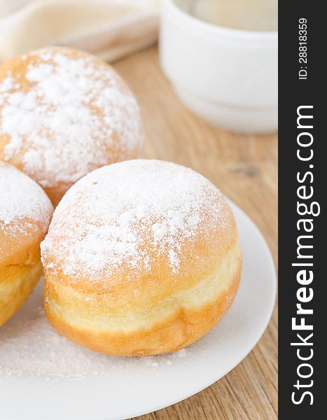 Sweet donuts dusted with icing sugar on the plate closeup. Sweet donuts dusted with icing sugar on the plate closeup