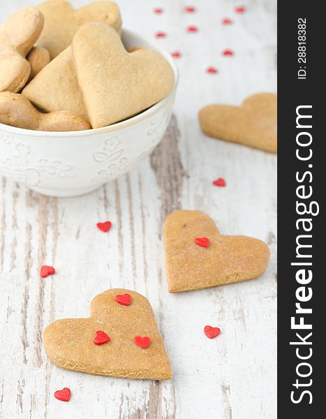 Cookies in the shape of a heart on the table and scattered sugar hearts. Cookies in the shape of a heart on the table and scattered sugar hearts