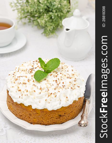 Pumpkin cake with cream and mint decorated with nuts and mint, vertical