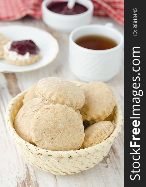 Scone of whole wheat in a wicker basket for breakfast vertical. Scone of whole wheat in a wicker basket for breakfast vertical