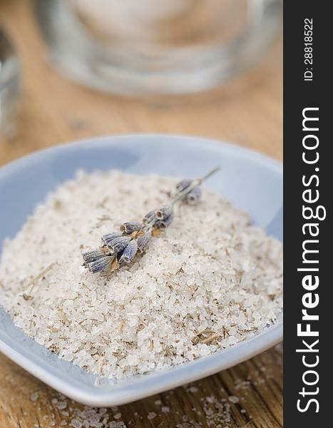 Sea salt with lavender in a blue bowl on wooden table closeup. Sea salt with lavender in a blue bowl on wooden table closeup