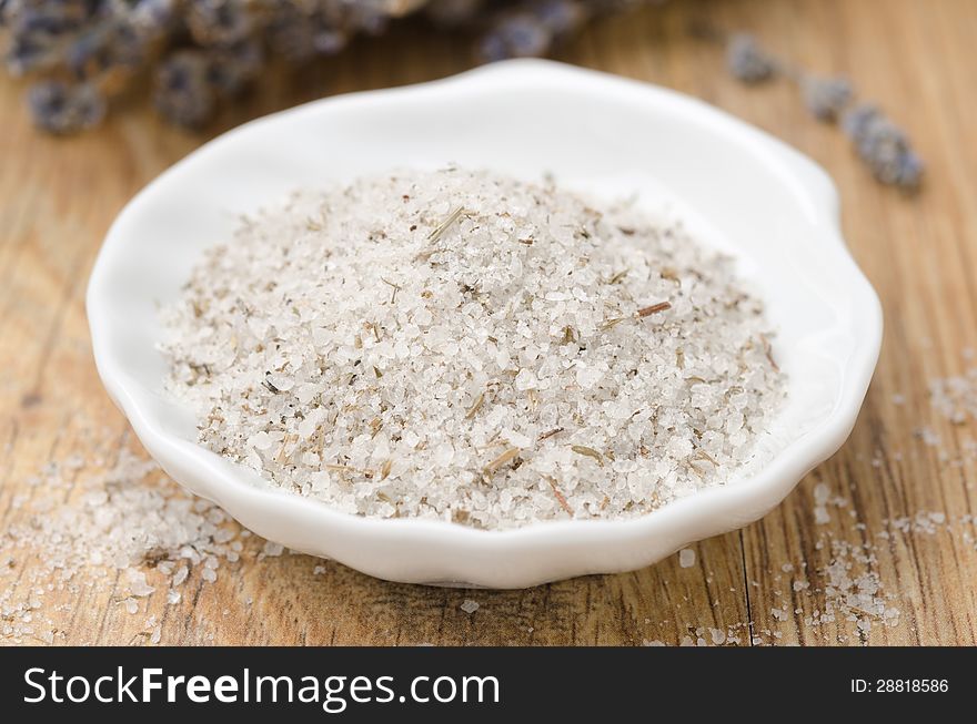 Sea ​​salt with lavender in a white bowl closeup horizontal. Sea ​​salt with lavender in a white bowl closeup horizontal