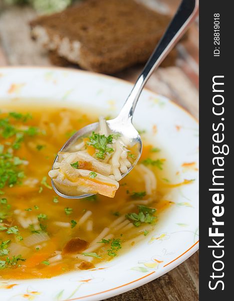 Spoon Of Chicken Soup With Noodles And Carrots Closeup Vertical
