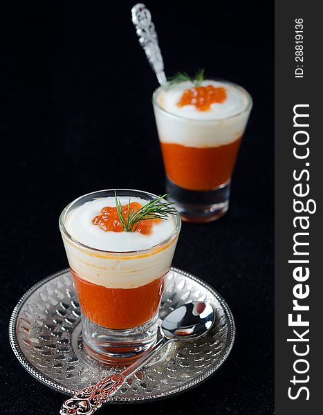Two appetizers in a glass goblet of sweet pepper, cream and red caviar