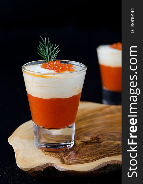 Two appetizers of sweet pepper, cream and red caviar in a glass goblet