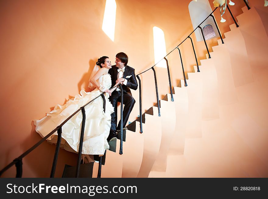 Happy bride and groom on ladder at wedding walk