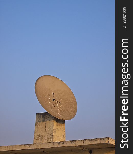 Old satellite dish on the roof of building