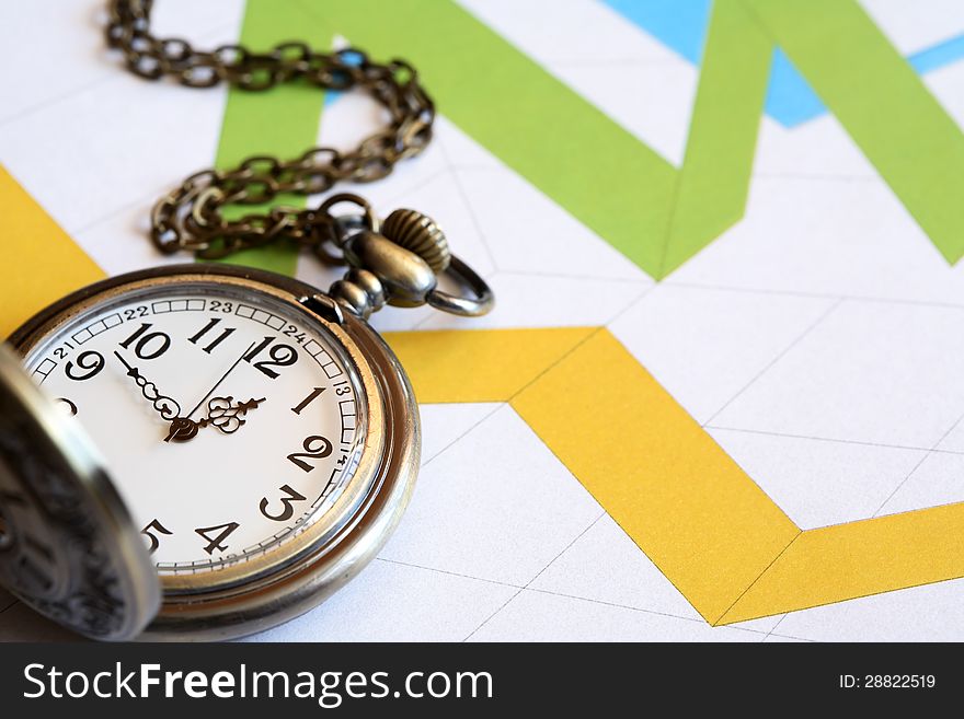 Business concept. Pocket watch on paper background with color chart. Business concept. Pocket watch on paper background with color chart