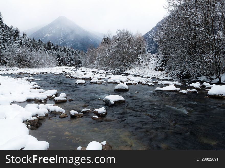 A winter landscape with river and mountain in the background. A winter landscape with river and mountain in the background