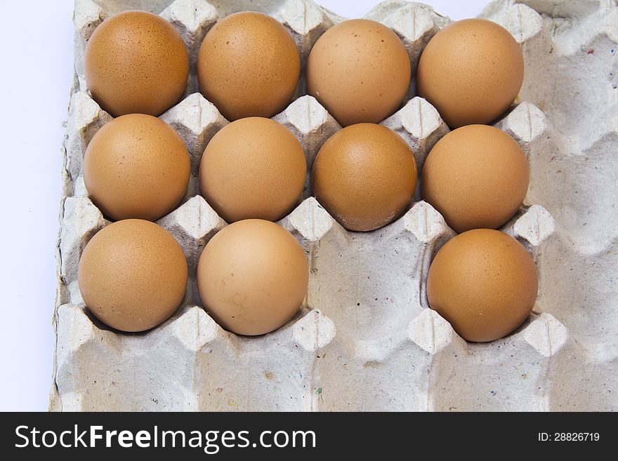 Closeup of many fresh brown eggs in carton tray