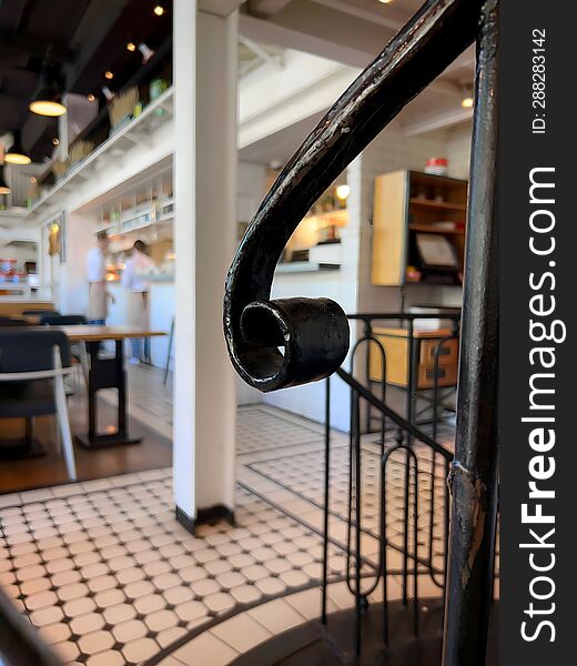 Black iron handle from the stairs in the bright interior of the restaurant