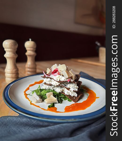 Salad With Mushrooms And Homemade Cheese In Sea Buckthorn Sauce On A Light Round Plate