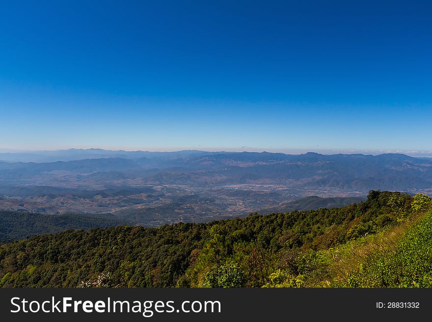 Mountain range and town in valley with blue sky, northern Thailand. Mountain range and town in valley with blue sky, northern Thailand