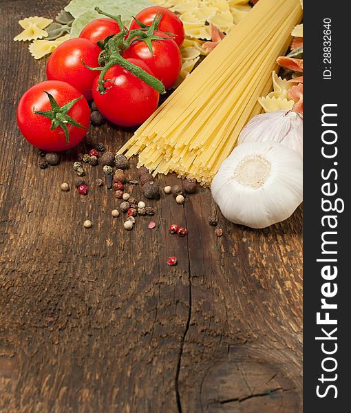 Pasta , tomatoes and garlic on a wooden background. Pasta , tomatoes and garlic on a wooden background