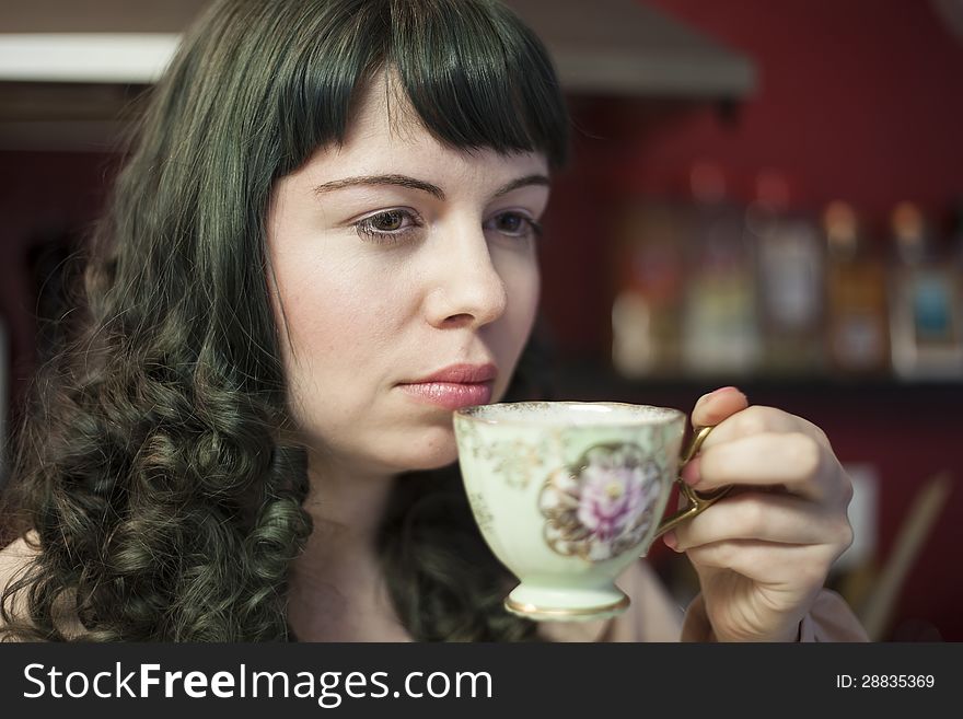 Portrait of a young woman with antique tea cup and saucer.