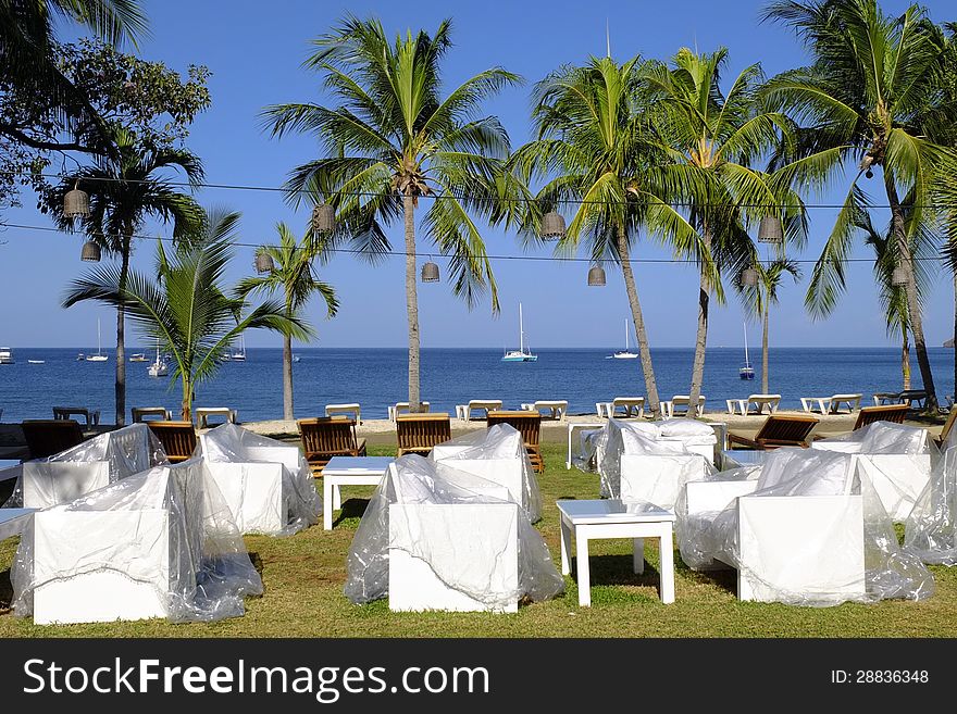 White chairs under transparent protection platic early in the morning with view on the Pacific ocean in Bahia Coco in Costa Rica. White chairs under transparent protection platic early in the morning with view on the Pacific ocean in Bahia Coco in Costa Rica