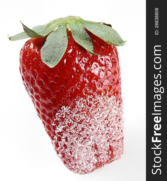 Closeup of a luscious fresh whole ripe red strawberry dipped in sugar with part of the green stem isolated on white. Closeup of a luscious fresh whole ripe red strawberry dipped in sugar with part of the green stem isolated on white