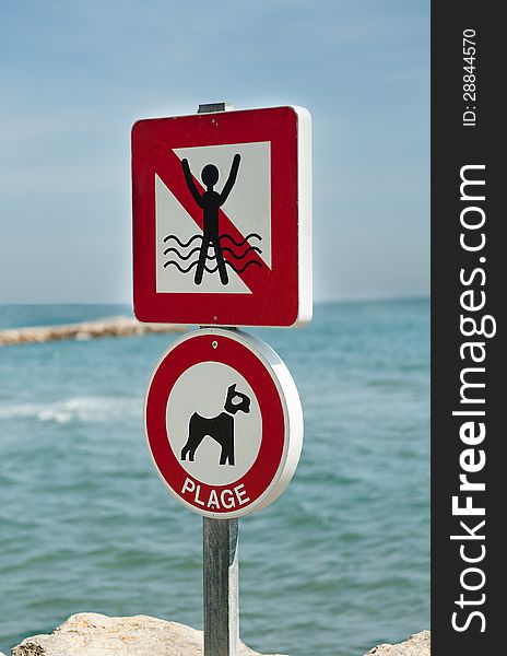 Signs prohibiting swimming and dog walking on the sea background. Signs prohibiting swimming and dog walking on the sea background