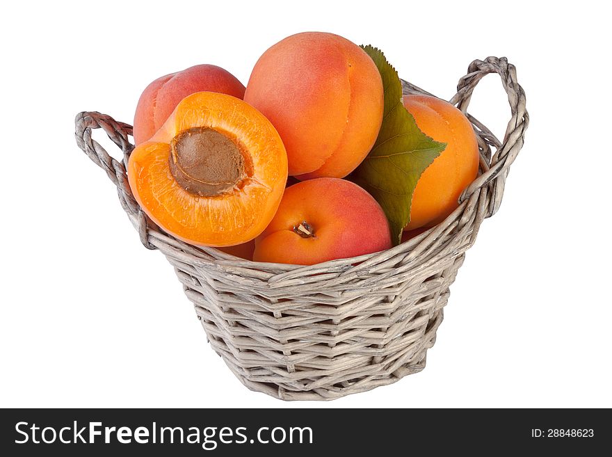 Apricots in basket isolated on white background