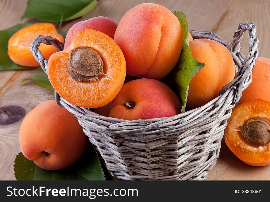 Fresh apricots with leaves on wood background. Fresh apricots with leaves on wood background