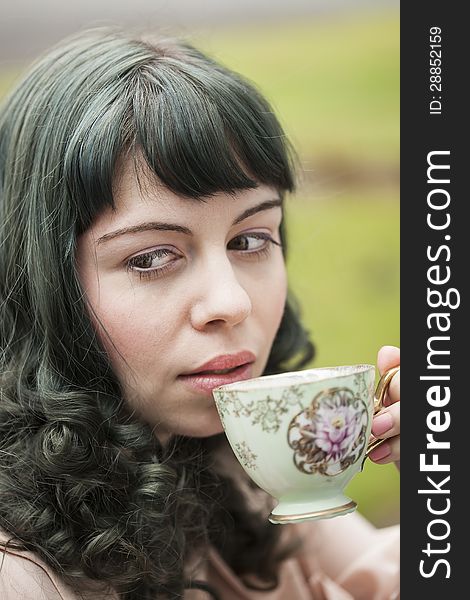 Portrait of a young woman with antique tea cup.