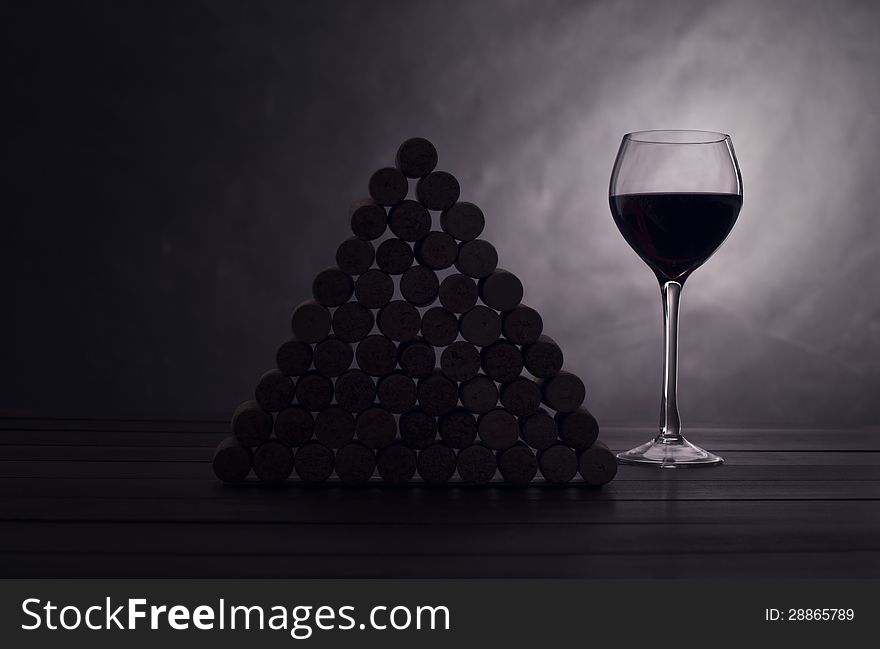 Glass with red wine near wine jams on a black background