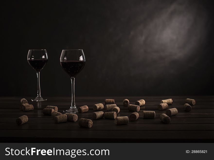 Two glasses of wine on a table with jams on a black background
