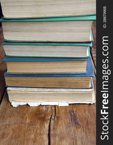 Stack of very old books on the cracked vintage wooden table. Stack of very old books on the cracked vintage wooden table