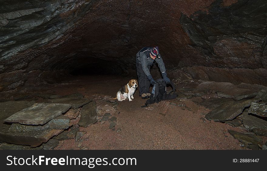 A man and a dog in a cave.