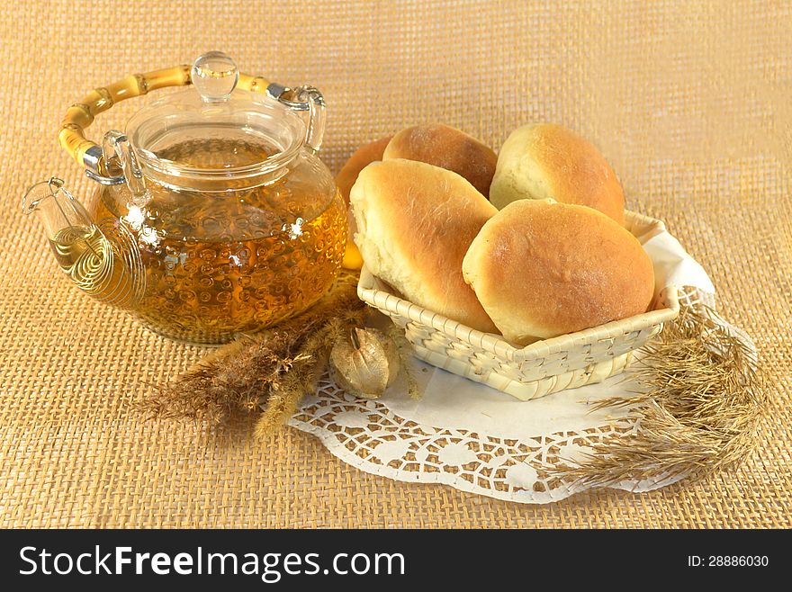 Teapot with stuffed buns and cereals on the napkin. Teapot with stuffed buns and cereals on the napkin