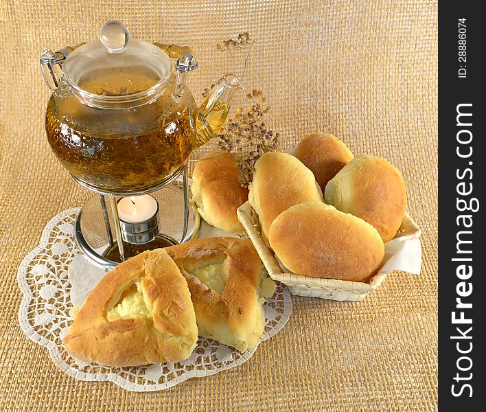 Teapot with stuffed buns and burning candle. Teapot with stuffed buns and burning candle