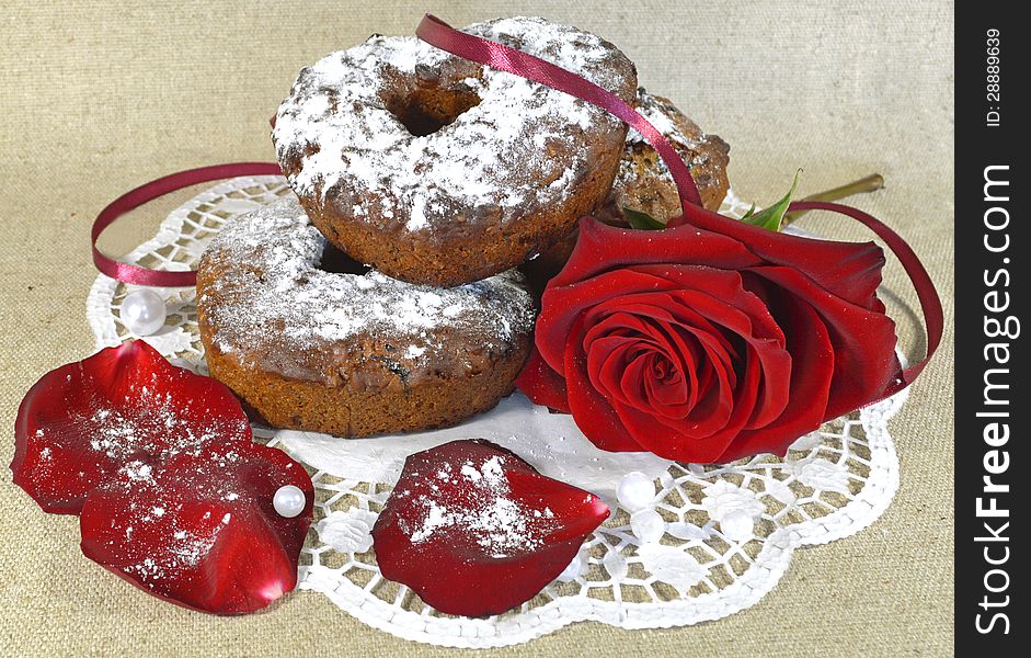 Red rose with chocolate cakes on the napkin. Red rose with chocolate cakes on the napkin