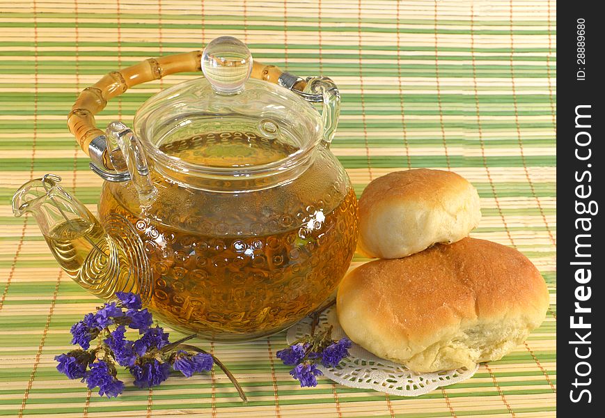 Teapot with stuffed buns and purple flowers. Teapot with stuffed buns and purple flowers