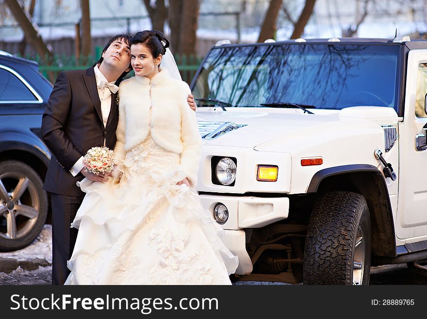 Happy bride and groom about wedding limousine