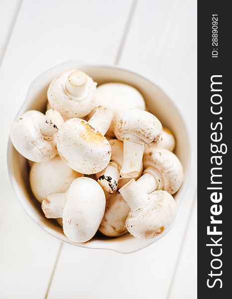 Agaricus bisporus- champignon mushrooms in a white bowl