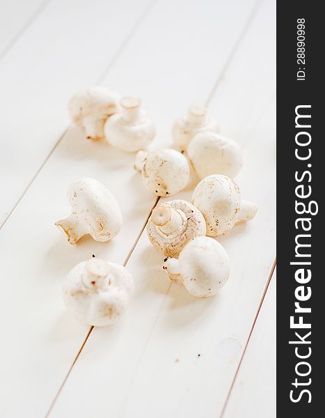 Fresh white champignon mushrooms on a wooden table. Fresh white champignon mushrooms on a wooden table