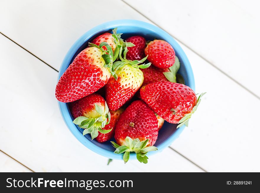 Big red strawberries in a blue pot